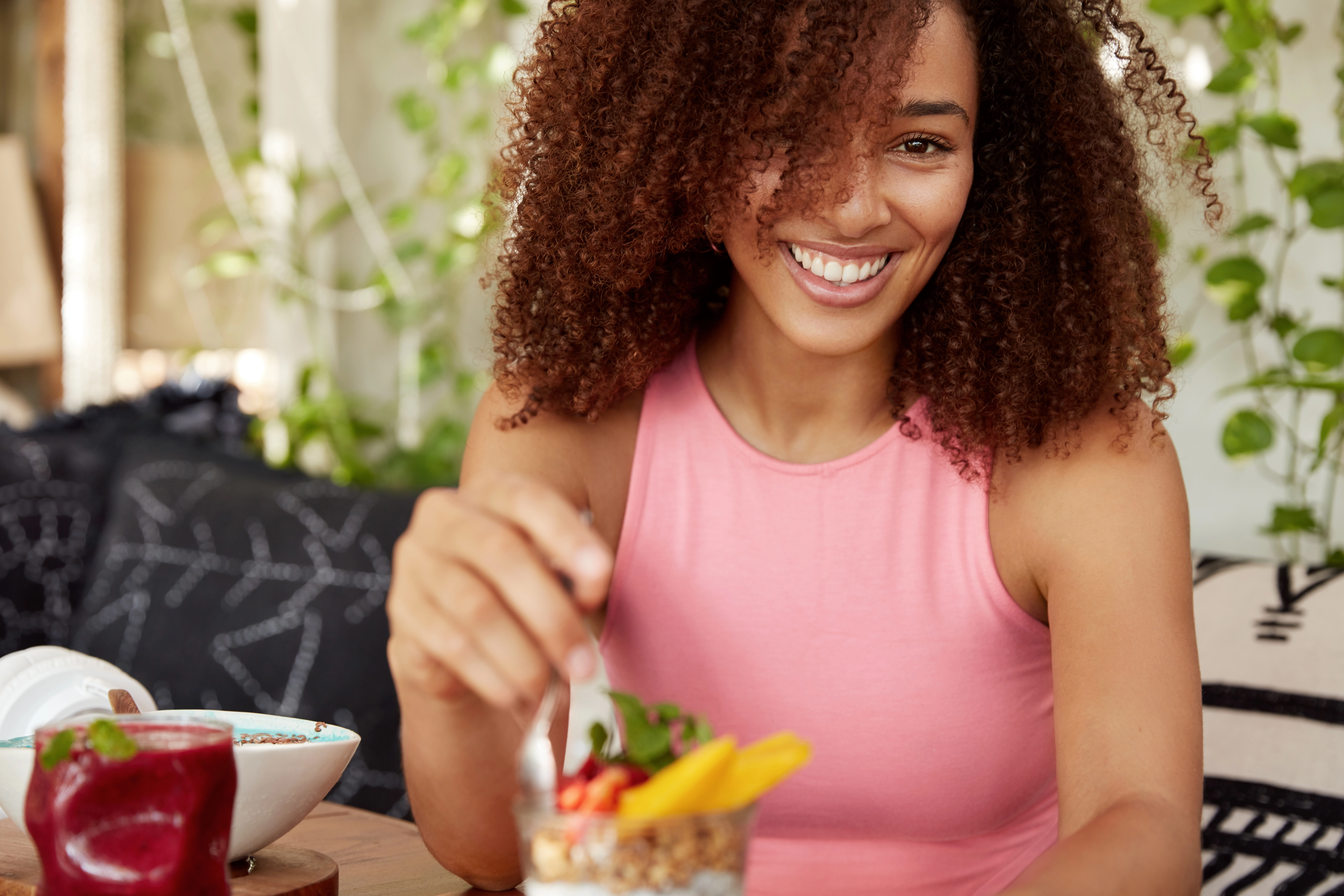 Plaisir alimentaire et contrôle des envies à Nyon Femme croquant un fruit — gestion des fringales et perte de poids naturelle à Nyon